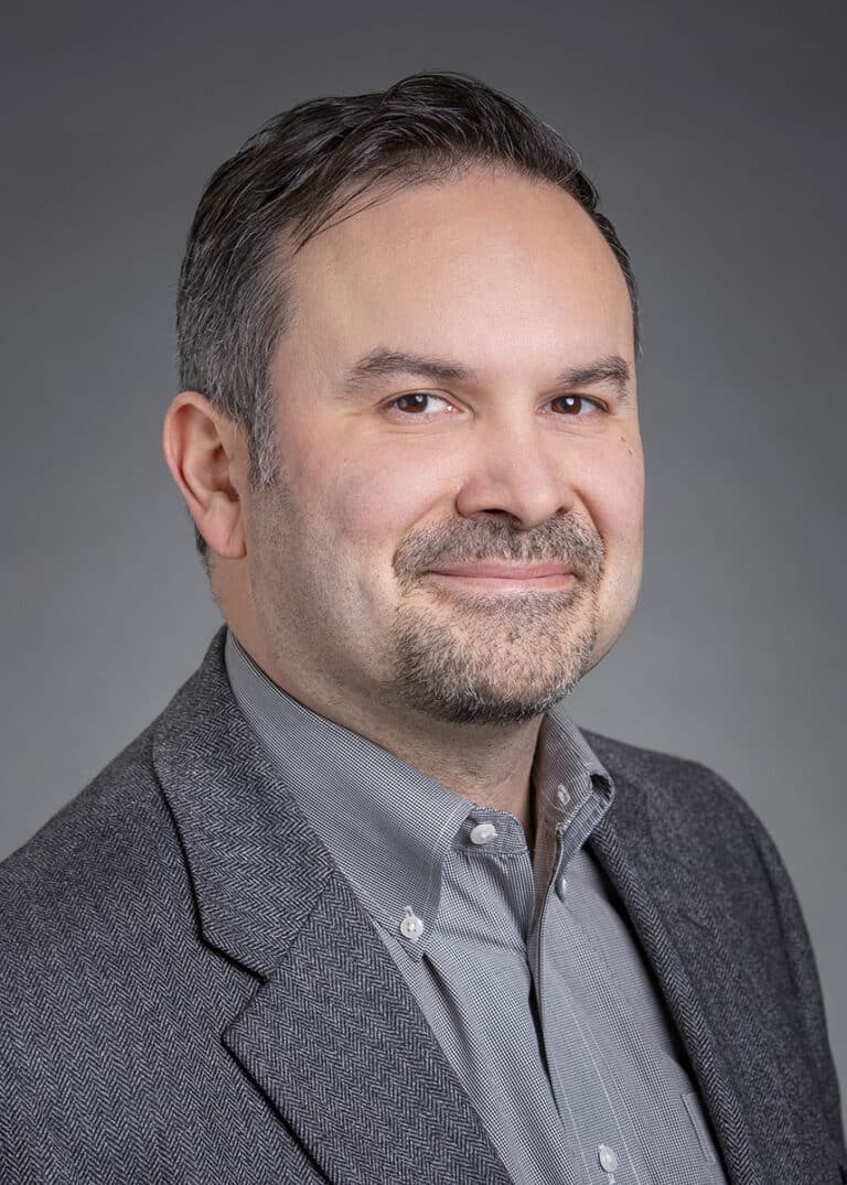 Man in a gray suit smiling