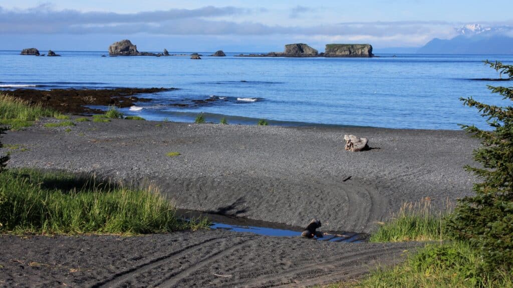 Sandy beach and large rocks and the sea in the background